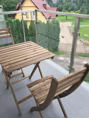 a wooden bench and a chair sitting on a porch at Apartament Julek klimatyzowany in Oświęcim