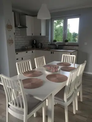 a kitchen with a white table with chairs and a table and a table and chairs at Apartament Julek klimatyzowany in Oświęcim