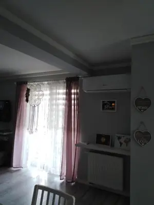 a living room with a window with pink curtains at Apartament Julek klimatyzowany in Oświęcim