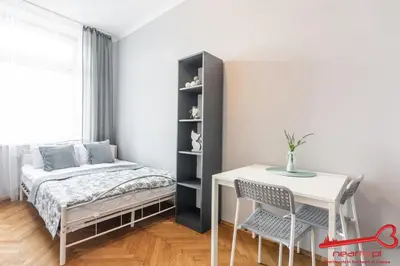 a dining room with a white table and a chair at Rooms Nearto Main Square in Kraków