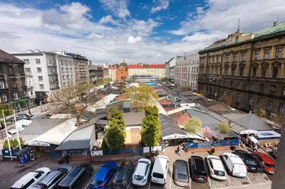 a white bedroom with a bed and a table at Rooms Nearto Main Square in Kraków