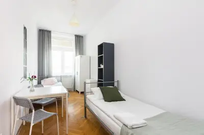 a white dining room with a table and chairs at Rooms Nearto Main Square in Kraków