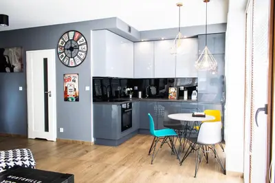 a kitchen with a table and chairs and a clock at Dream LUX Apartments in Kraków