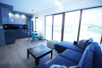 a living room with a blue couch and a table at Dream LUX Apartments in Kraków