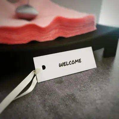 a white tag with the word welcome on a table at Dream LUX Apartments in Kraków