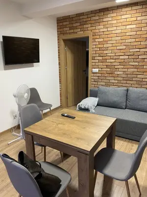a living room with a table and chairs and a couch at Route 7 Rooms in Myślenice