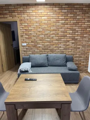 a living room with a blue couch and a wooden table at Route 7 Rooms in Myślenice
