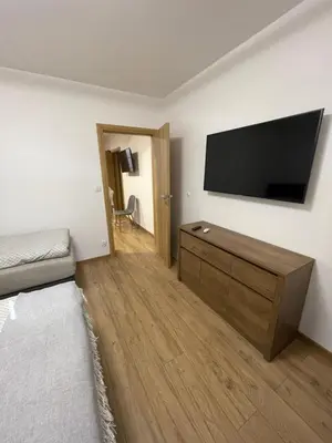 a bedroom with a flat screen tv on a wall at Route 7 Rooms in Myślenice