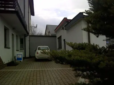 a car parked in a parking lot between two buildings at Route 7 Rooms in Myślenice