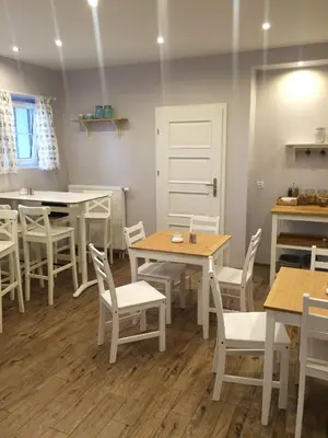 a dining room with tables and white chairs at Route 7 Rooms in Myślenice