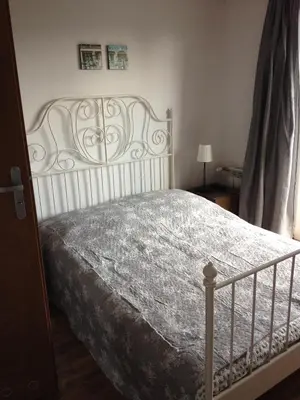 a bedroom with a white bed with a white headboard at Route 7 Rooms in Myślenice