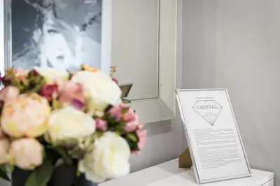 a vase of flowers sitting next to a sign at Crystal Luxury Apartments Rakowicka 22H in Kraków