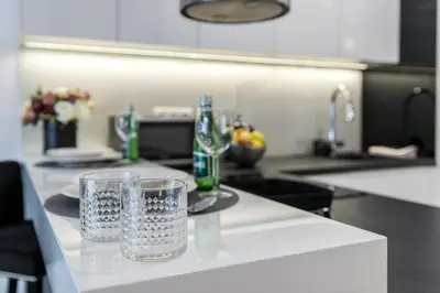 a kitchen counter with two glasses and bottles on it at Crystal Luxury Apartments Rakowicka 22H in Kraków