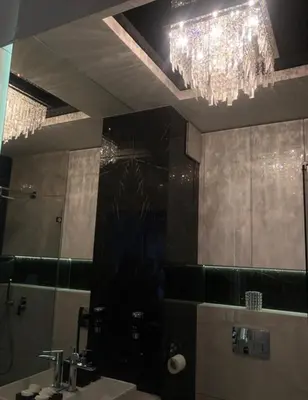 a bathroom with a chandelier and a sink and a mirror at Crystal Luxury Apartments Rakowicka 22H in Kraków