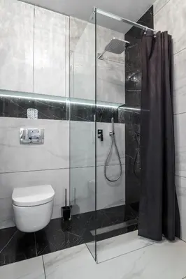 a bathroom with a toilet and a glass shower at Crystal Luxury Apartments Rakowicka 22H in Kraków