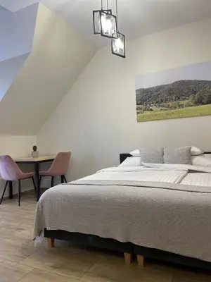 a bedroom with a bed and a table with a chair at Dwór Bysina in Myślenice