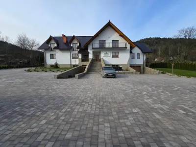 a house with a car parked in a driveway at Dwór Bysina in Myślenice