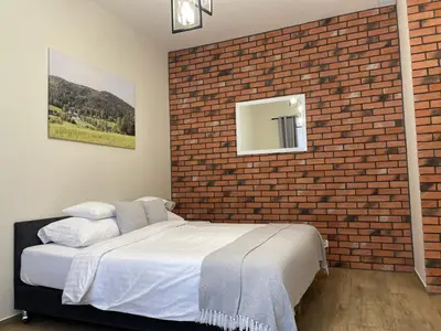 a bedroom with a brick wall and a bed at Dwór Bysina in Myślenice