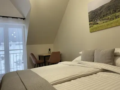 a bedroom with a bed and a table and a window at Dwór Bysina in Myślenice
