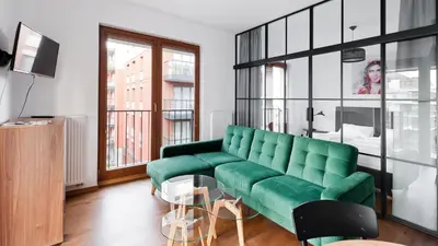 a living room with a green couch and a window at Rakowicka Podkowa City Center, Sun & Snow in Kraków