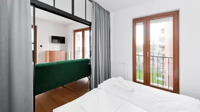 a bedroom with a green bed and a large mirror at Rakowicka Podkowa City Center, Sun & Snow in Kraków