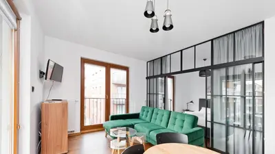 a living room with a green couch and a table at Rakowicka Podkowa City Center, Sun & Snow in Kraków
