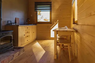 a kitchen with a wooden table and a stove at Jeżowa Woda Ośrodek Wypoczynkowy Palmiarnia i SPA in Przyszowa