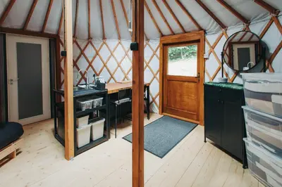 a room in a yurt with a desk and a door at Jeżowa Woda Ośrodek Wypoczynkowy Palmiarnia i SPA in Przyszowa