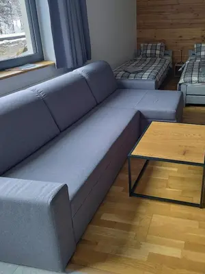 a blue couch in a living room with a table at Jeżowa Woda Ośrodek Wypoczynkowy Palmiarnia i SPA in Przyszowa