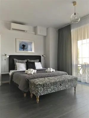 a bedroom with a large bed with a bench at Apartamenty Retmana in Kraków