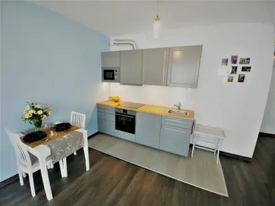a kitchen with a table and a sink and a table and chairs at Apartamenty Retmana in Kraków