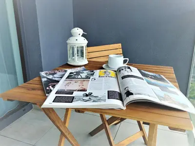 a table with a magazine on top of a wooden table at Apartamenty Retmana in Kraków