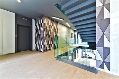 a room with a staircase with a glass railing at Apartamenty Retmana in Kraków