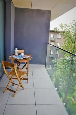 a balcony with a table and chairs on a balcony at Apartamenty Retmana in Kraków
