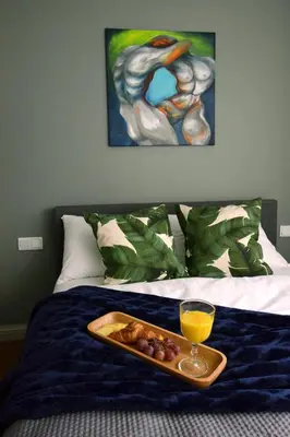 a tray of fruit and a glass of orange juice on a bed at Wawrzyńca Brick Apartment Kazimierz in Kraków