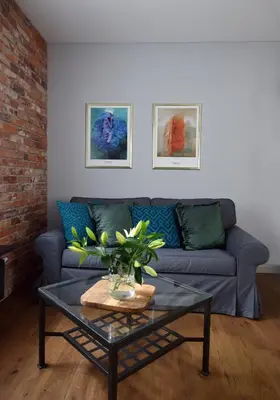 a living room with a couch and a glass table at Wawrzyńca Brick Apartment Kazimierz in Kraków