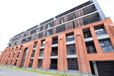 a large red brick building with a lot of windows at Wawrzyńca Brick Apartment Kazimierz in Kraków
