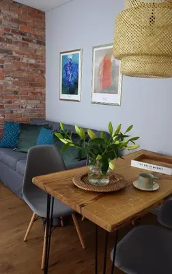 a living room with a table and a couch at Wawrzyńca Brick Apartment Kazimierz in Kraków