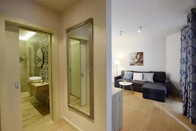a living room with a couch and a mirror at Piłsudskiego In City Apartments in Kraków