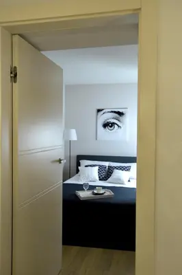 a bedroom with a bed with a eye on the wall at Piłsudskiego In City Apartments in Kraków