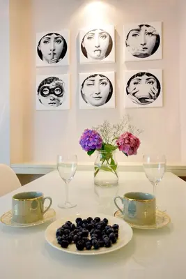 a table with a plate of fruit and glasses and flowers at Piłsudskiego In City Apartments in Kraków