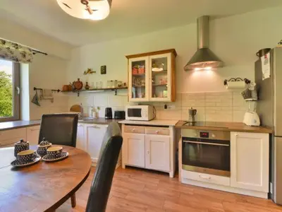 a kitchen with a wooden table and a dining room at Ranczo Dziki Sad in Raciechowice