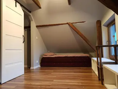 a bedroom with a bed in a attic at Ranczo Dziki Sad in Raciechowice