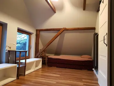 a bedroom with a bunk bed and a tub and a window at Ranczo Dziki Sad in Raciechowice