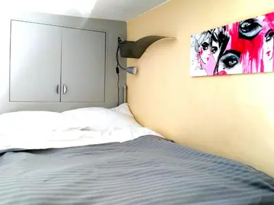 a bedroom with a bed and a painting on the wall at Studio Estery in Kraków
