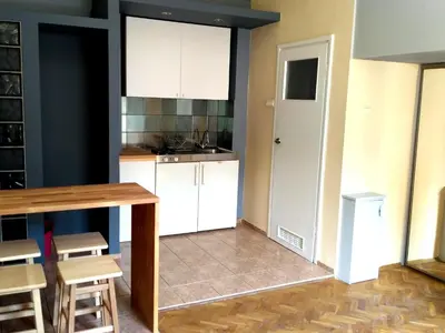 a kitchen with white cabinets and a table and chairs at Studio Estery in Kraków