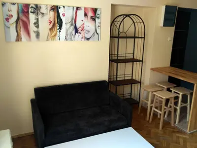 a living room with a black couch and a table at Studio Estery in Kraków