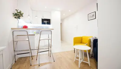 a kitchen with a counter and stools in a room at Rakowicka Apartament in Kraków