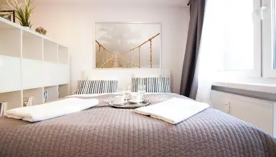 a bed with a table with towels on it at Rakowicka Apartament in Kraków