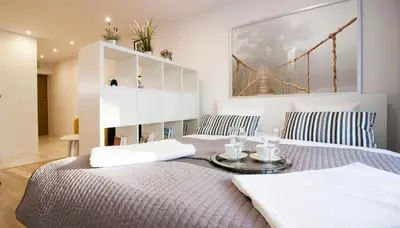 a bedroom with a bed and a bridge painting on the wall at Rakowicka Apartament in Kraków